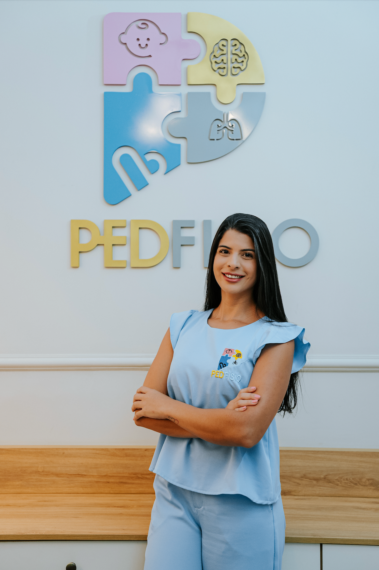 Fisioterapeuta pediátrica apoiando bebê em sessão de desenvolvimento motor